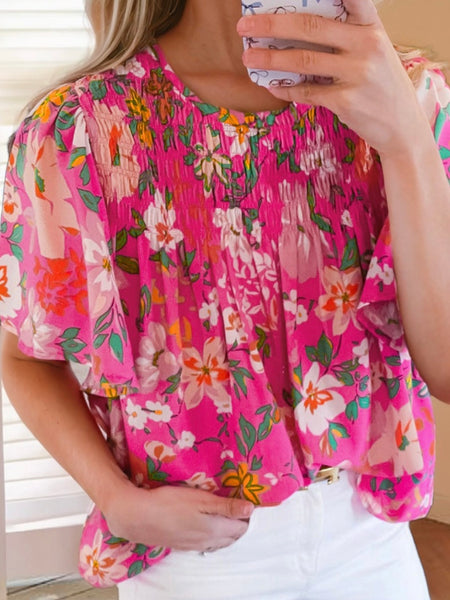  Pink Smocked Blouse ,features a pink floral print and flutter sleeves , perfect for any occasion .