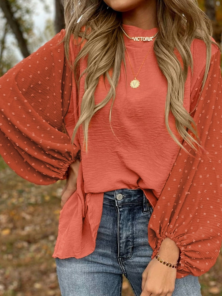 Orange , Balloon Sleeve Top, with a Contrasting Swiss Dot Pattern, and Elegant Keyhole Detailing. The stylish keyhole opening and dainty gold button closure on the back provide a chic finish. 