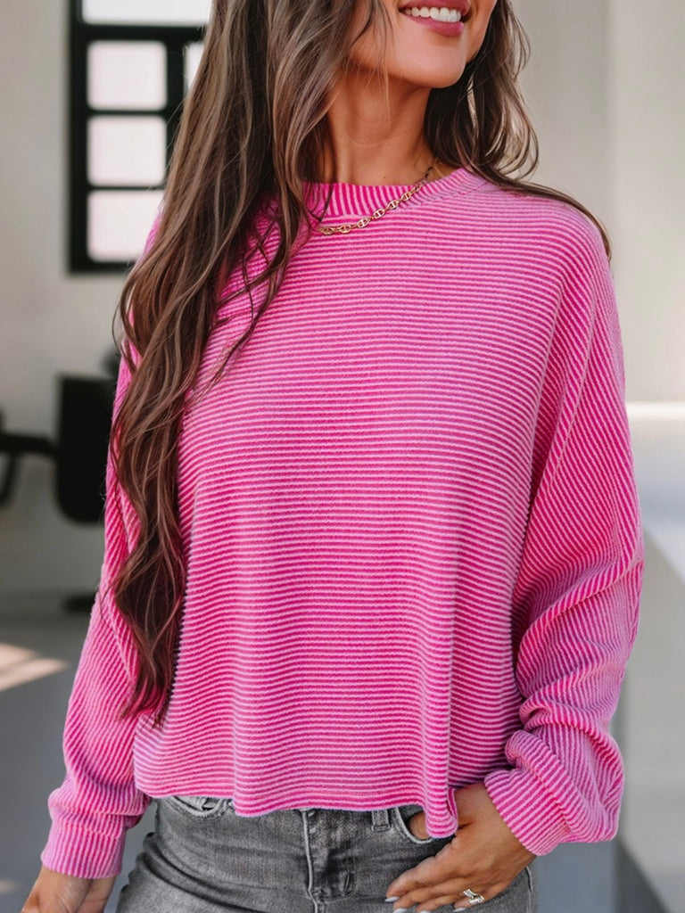 Pink corded top with long sleeves.
