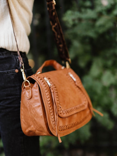 Brown vegan leather purse with adjustable leopard strap and 2 zippered pockets and gold hardware.