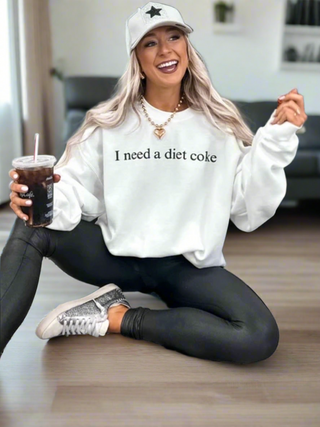 I Need A Diet Coke Sweatshirt, featuring a classic white base with black front font.