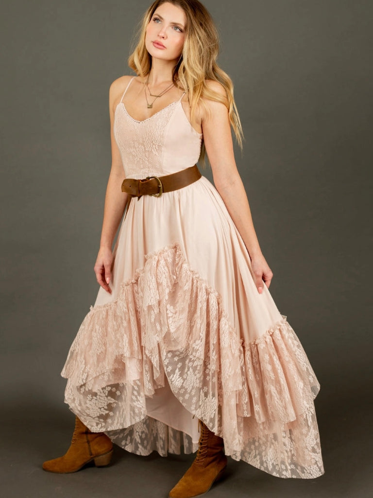 Dramatic ruffle hemline, featuring a faux wrap skirt and lace details, with a smocked back and adjustable straps for a flattering fit. Made of 100% rayon with raw edge finishing and lined for comfort. Let your boho vibes shine in this shell-colored dress. 