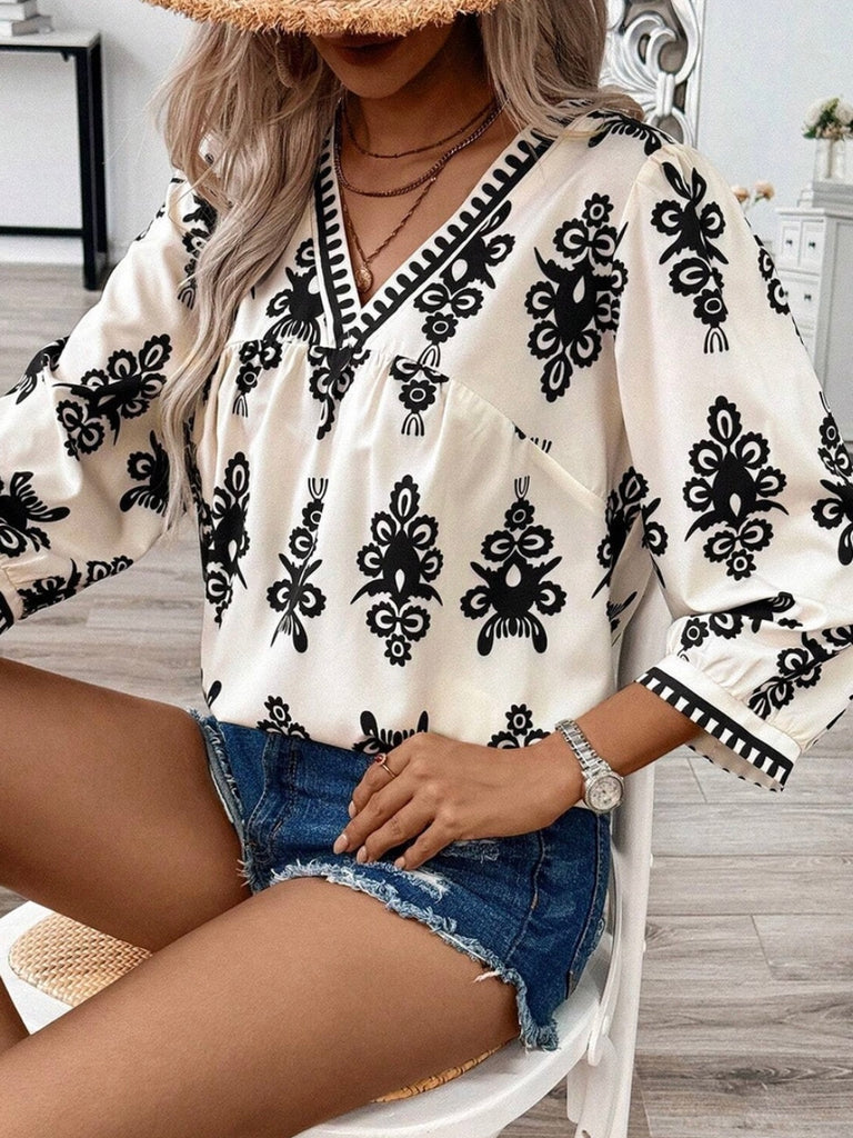  Features V-neck with delicate puff sleeves in a creamy color with a black print ikat design .