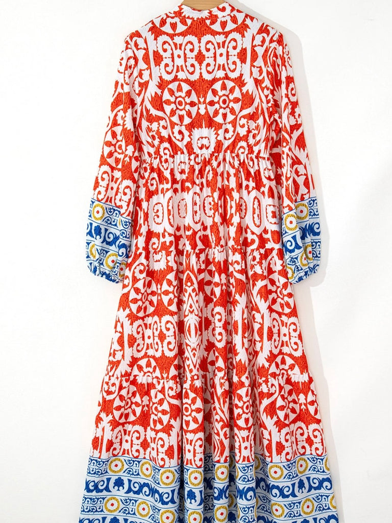  Long Boho Maxi Dress, in a beautiful Spanish print, with a Unique Geometric Pattern, accented by vibrant orangey-red and blue motifs.