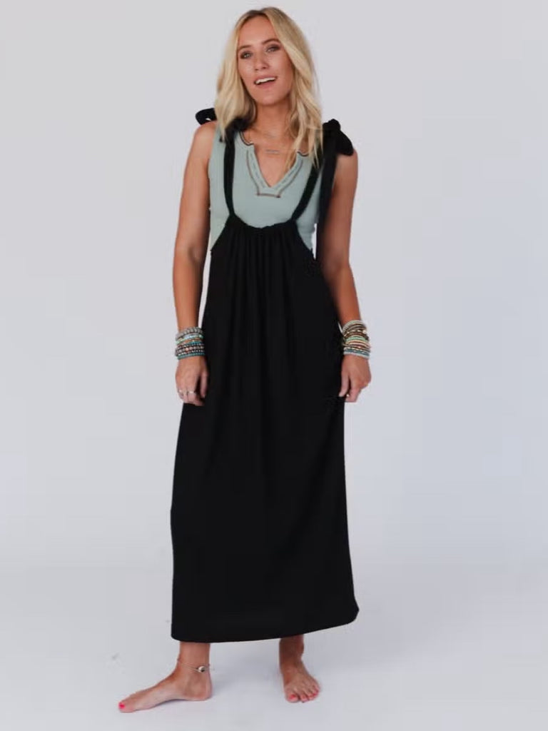 Black stretchy dress with adjustable straps,  a scoop waistline and pockets.
