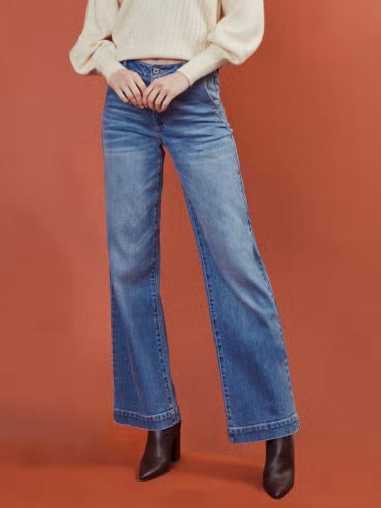 Kancan high rise trouser wide leg jeans sits above the waist and relaxes down the leg. Comes in a medium wash with light fading and whiskering.  Features 2 front deep-pockets, light distress detail, single front button closure, and zip fly.