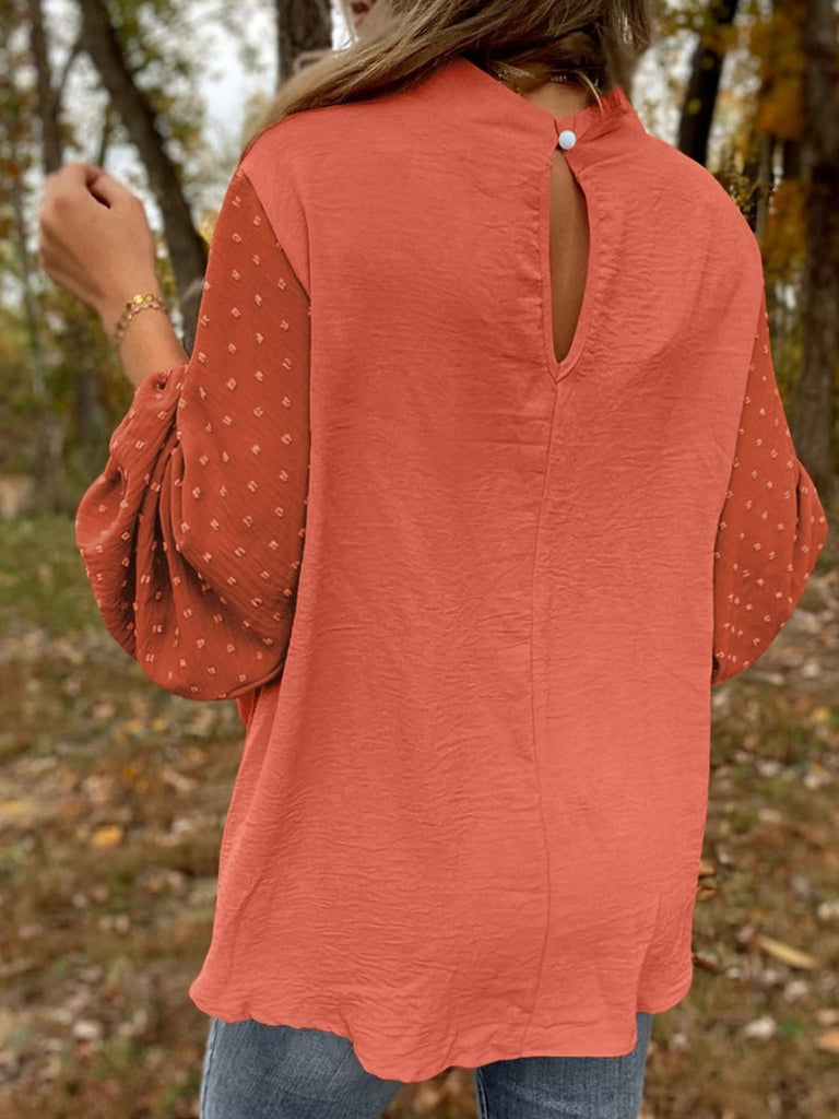 Orange , Balloon Sleeve Top, with a Contrasting Swiss Dot Pattern, and Elegant Keyhole Detailing. The stylish keyhole opening and dainty gold button closure on the back provide a chic finish. 