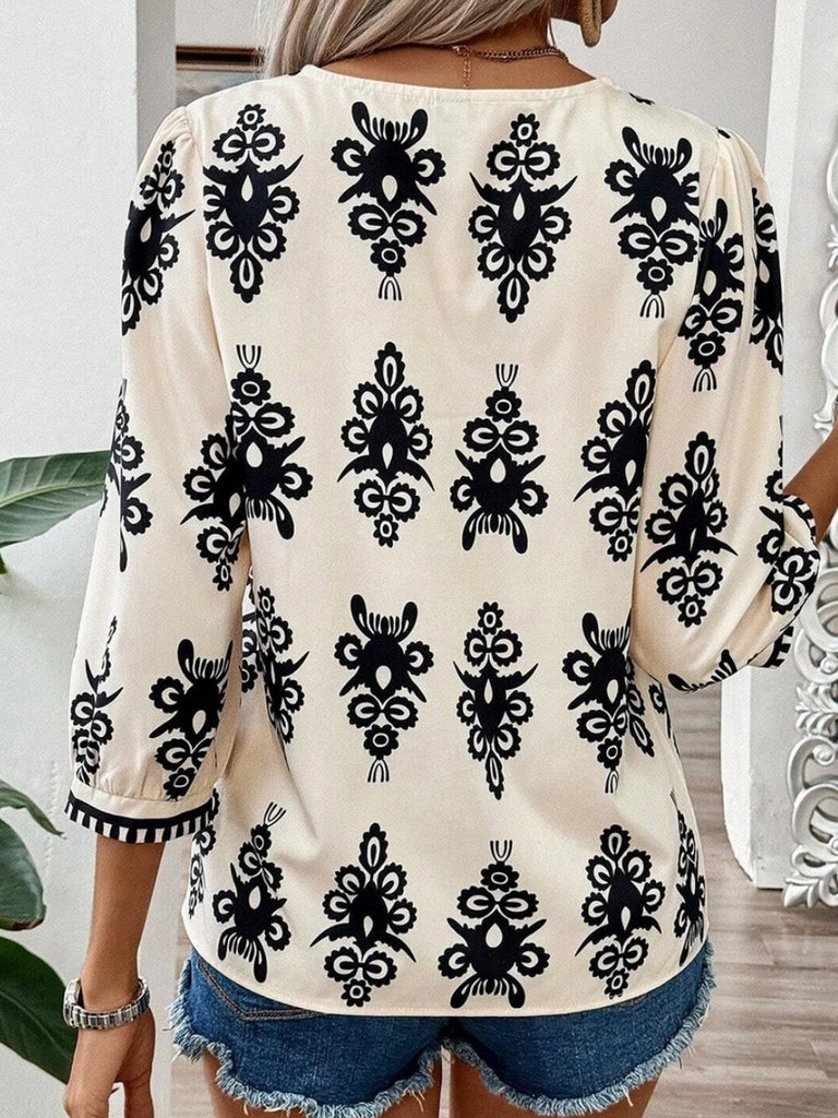  Features V-neck with delicate puff sleeves in a creamy color with a black print ikat design .