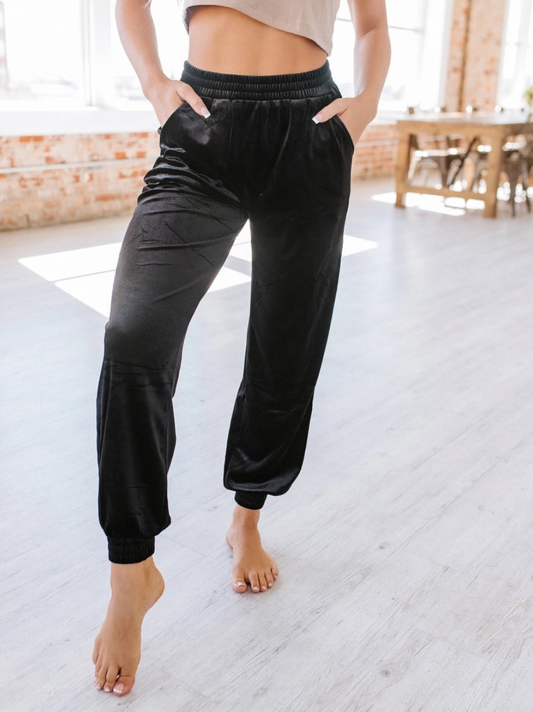Black velvet joggers with elasticized waist and ankles.