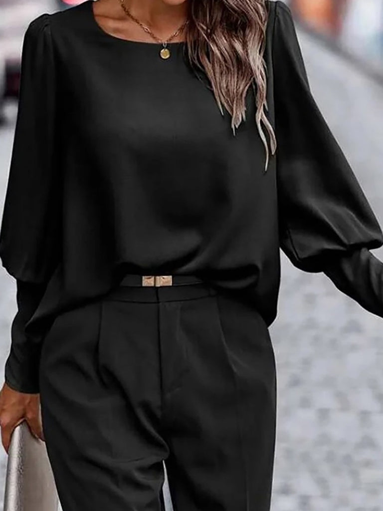 Black puffed sleeved blouse with back button detail.