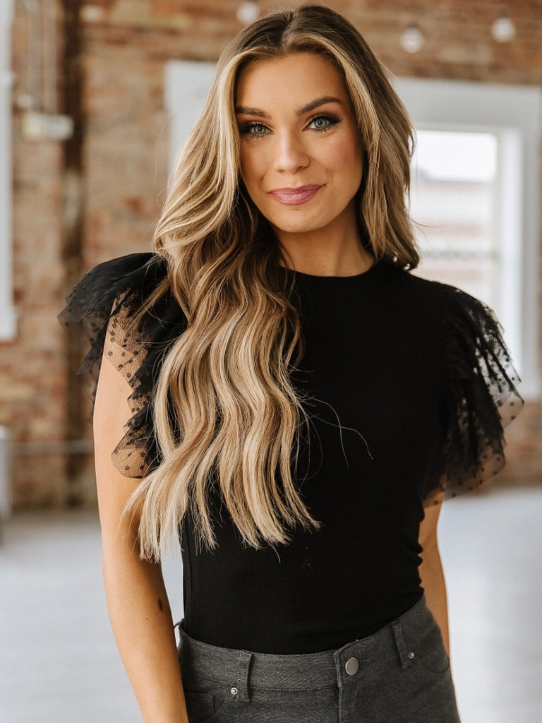 Black top with lace ruffle sleeve.