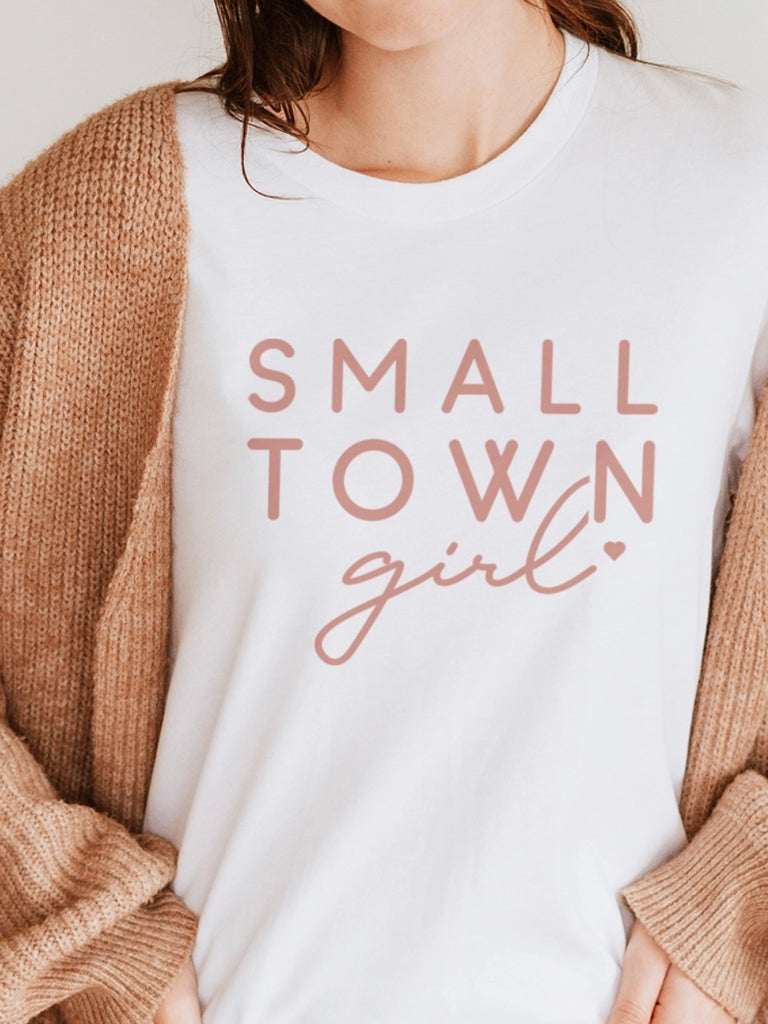  Relaxed Fit White Tee, features a charming blush pink "Small Town Girl" font made from lightweight, super-soft fabric for ultimate comfort.