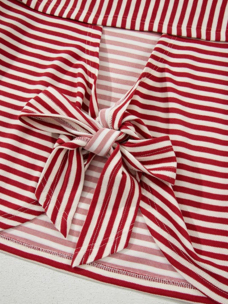 Close-up of the back tie detail on a pink striped top featuring an open back and statement bow.