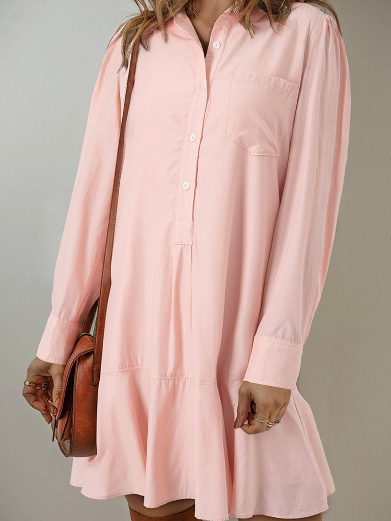 Light pink long sleeve shirt dress with button front, styled with a clutch bag