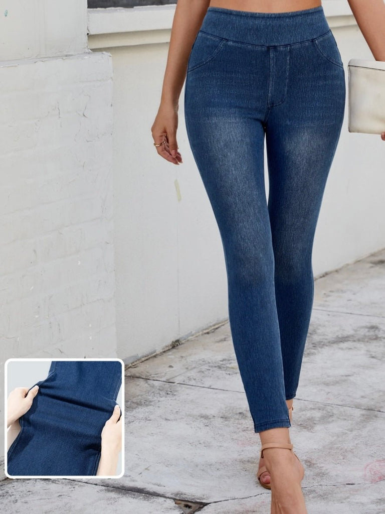 Model wearing dark wash denim jeggings with faux front pockets and a slim fit silhouette.