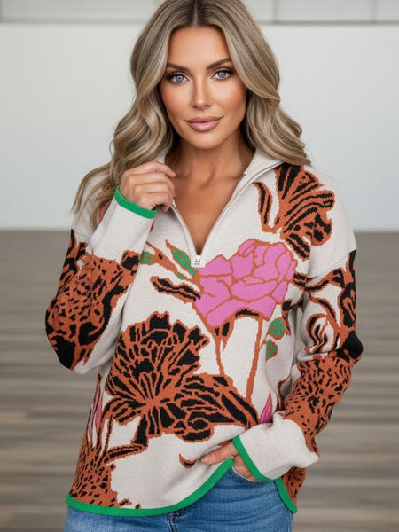 Woman wearing a patterned sweater with floral and animal print design.