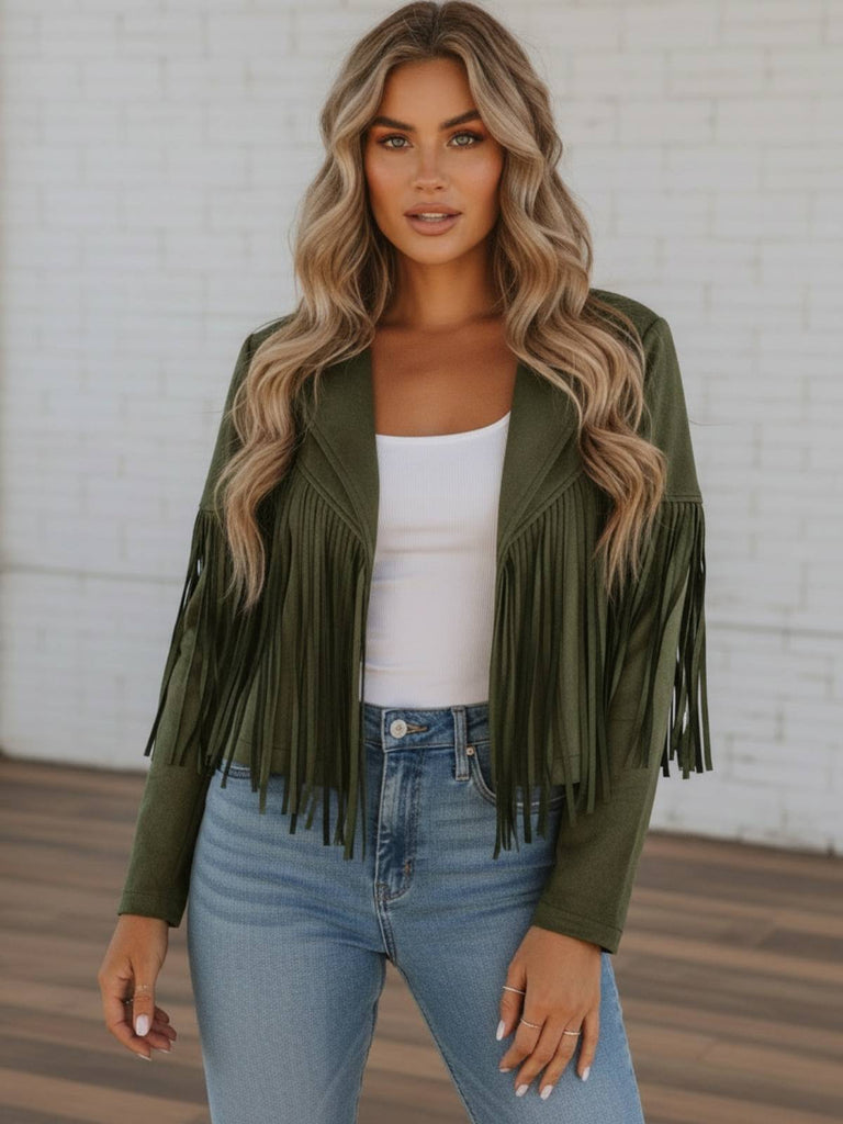 Woman wearing a green fringe boho faux leather jacket, white top, and blue jeans from Oak&Pearl Clothinf Co