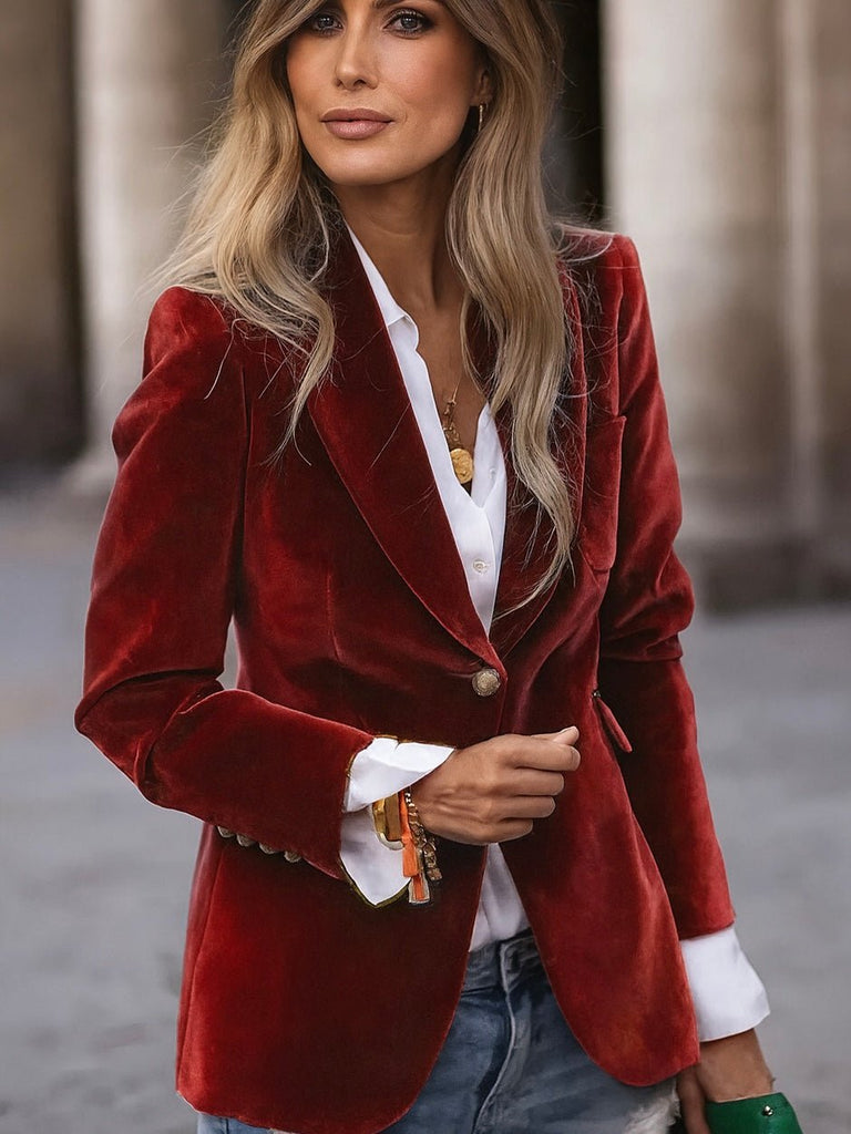 Woman wearing a red velvet blazer over a white shirt with a blurred background