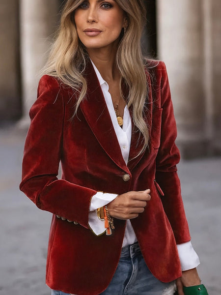 Woman wearing a red velvet blazer over a white shirt with a blurred background