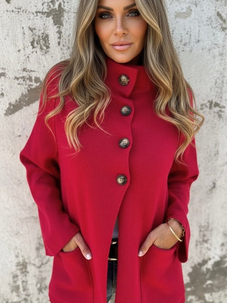 Woman wearing a red cape style coat with brown buttons from Oak&Pearl Clothing Co.