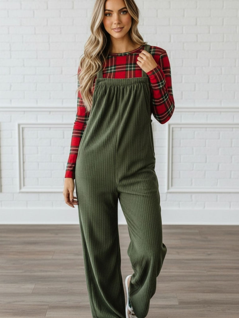Woman in olive green ribbed knit overalls with wide legs, layered over a red plaid fitted top, Oak & Pearl Clothing Co.