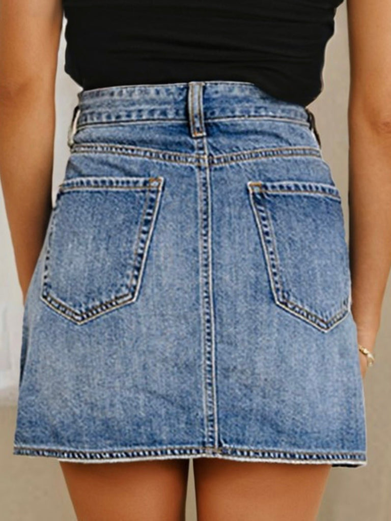 Back view of a blue denim mini skirt featuring classic pockets and faded wash detail.