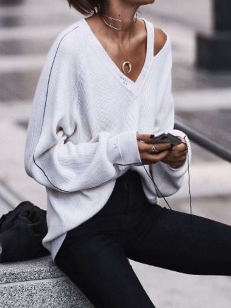 White loose fit, cold shoulder sweater with a cut out neckline and black sleeve accents.