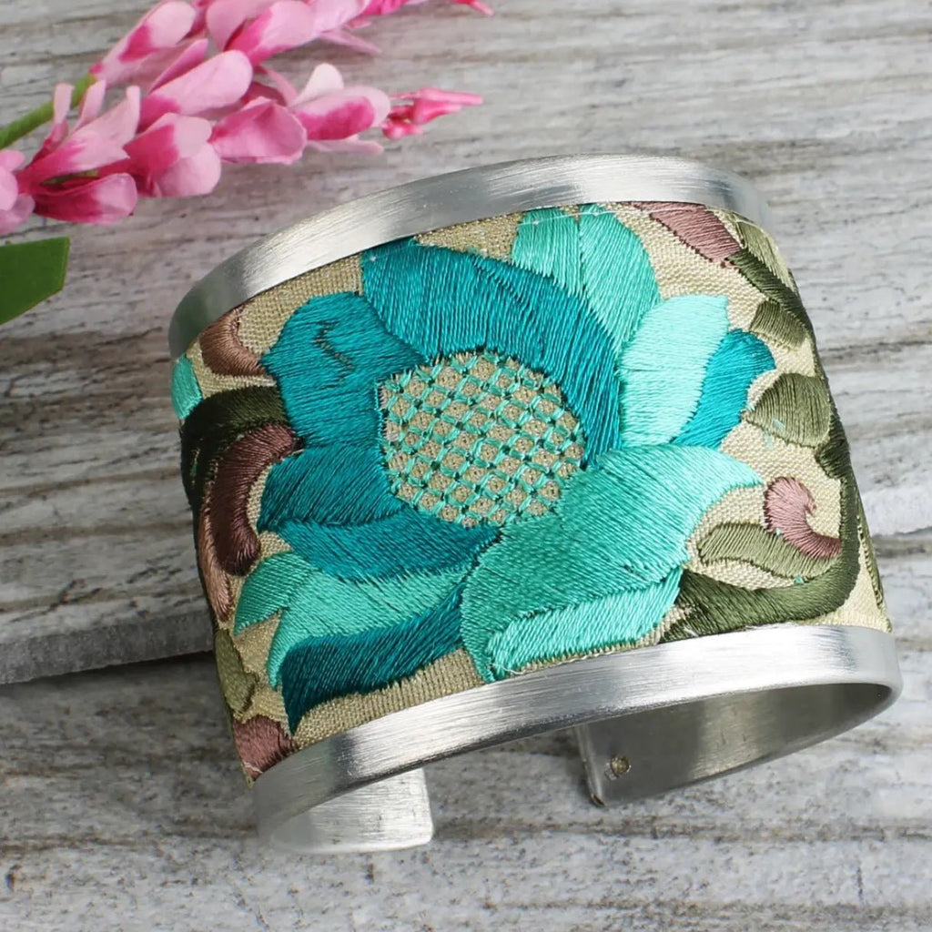 2" Wide Brushed Silver Cuff with bold cream coloured fabric embroidered with turquoise and purple floral designs.